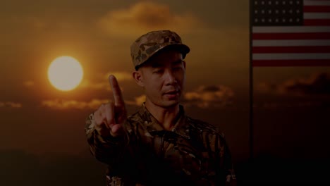 close up of asian man soldier pointing at you and disapproving with no index finger sign while standing with flag of the united states, sunset time