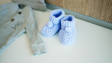 cute tiny cap, shirt and socks for the newborn baby. clothes prepared for the child by parents. close up.
