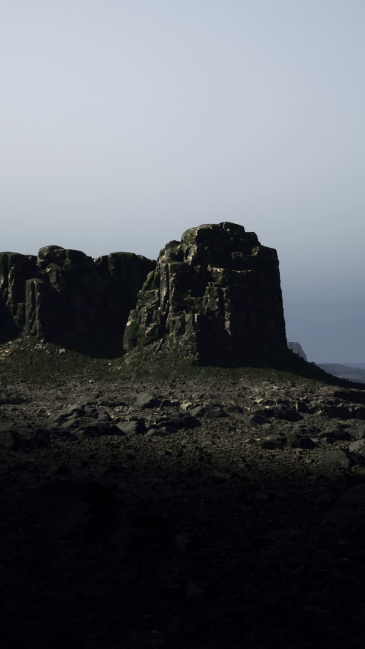 Drammatiche scogliere rocciose sotto una luce fioca vicino a una vasta costa al crepuscolo