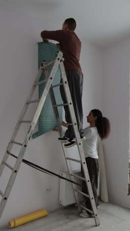 couple hanging wallpaper together