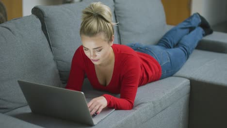 Attraktive-Frau-Mit-Laptop-Auf-Dem-Sofa