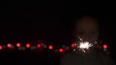 el niño feliz tiene una chispa de año nuevo en la mano.