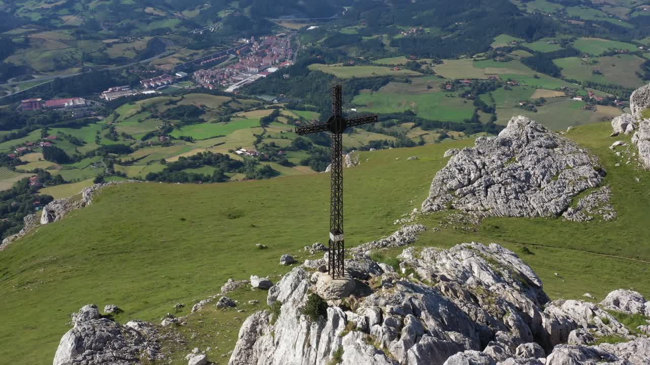 vista aérea de drones de una gran cruz de hierro en la cima de una montaña en el país vasco