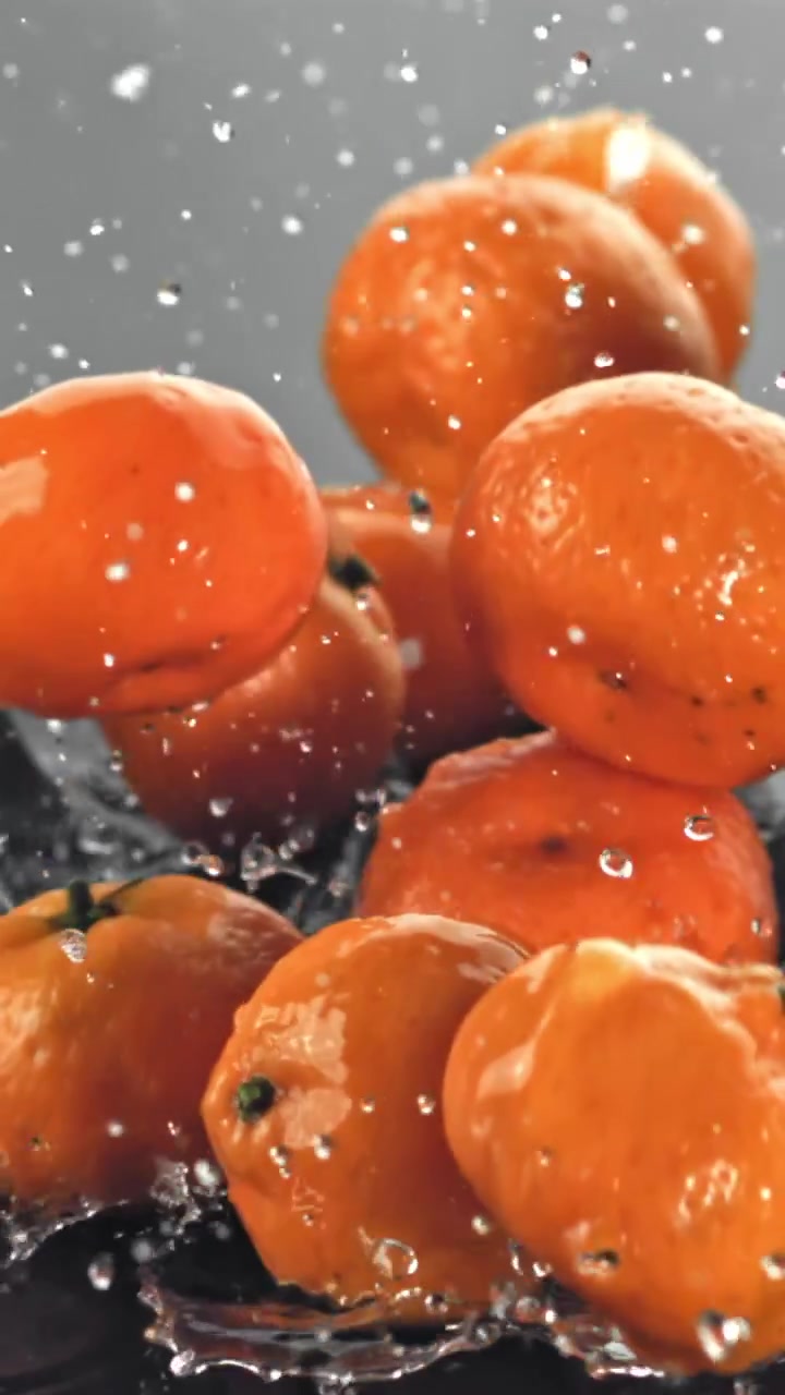 Friske mandariner plasker ned i vand i slow motion