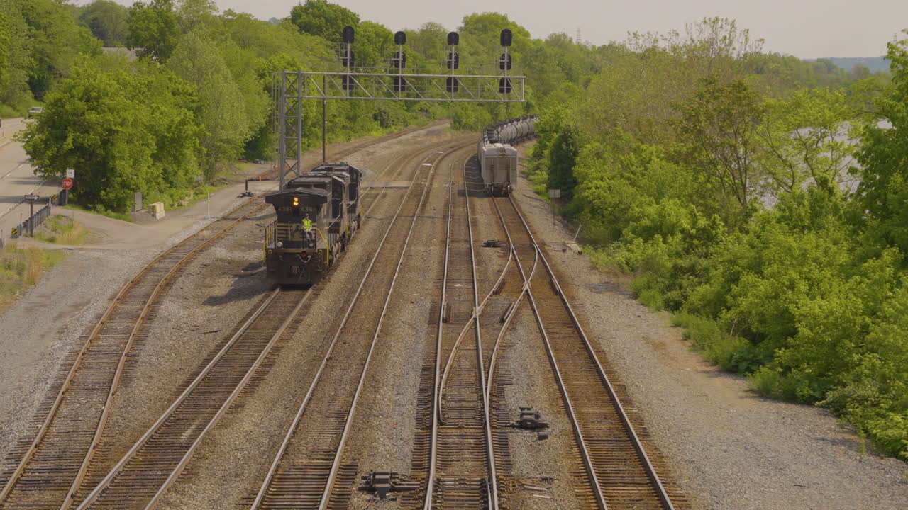 열차 엔진이 버려진 열차 교차로에서 백업하고 있습니다.