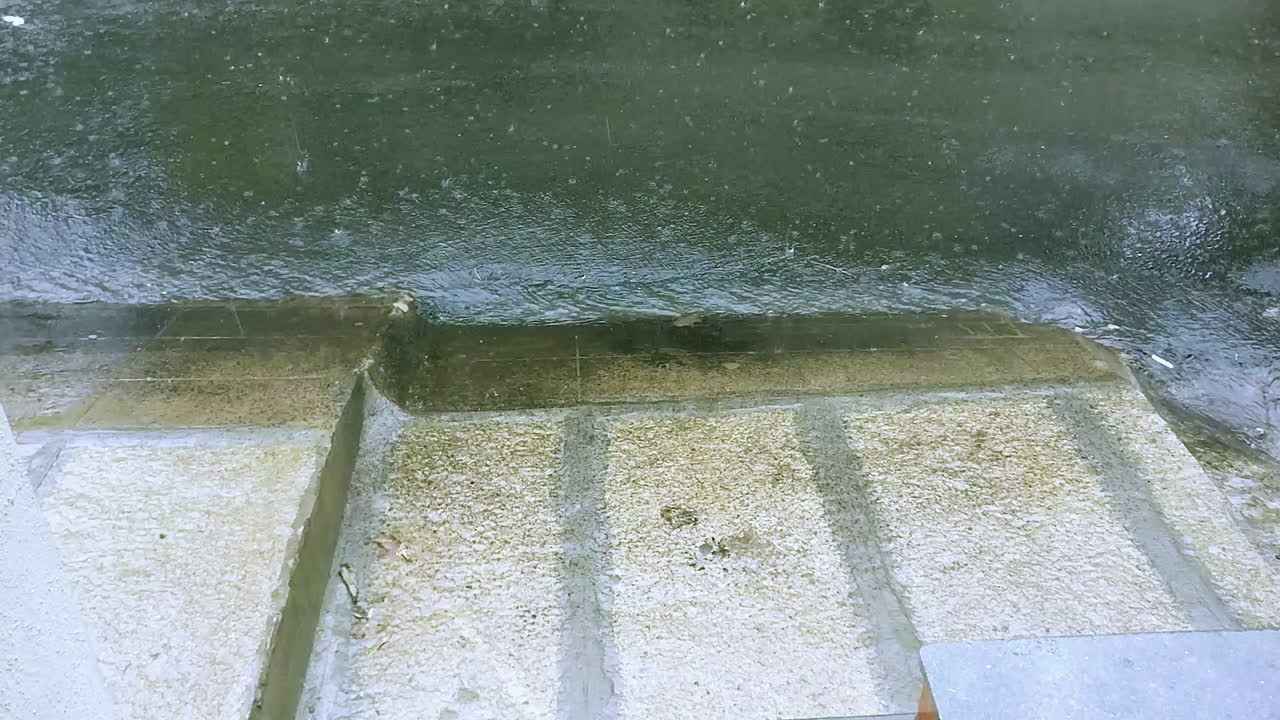 폭우 시 배수구 아래로 흐르는 작은 물줄기