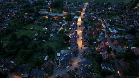 dusk scene with illuminated roads in american neighborhood. nightscape in historic suburb residential area of united states. parking cars along street. aerial top down flyover shot