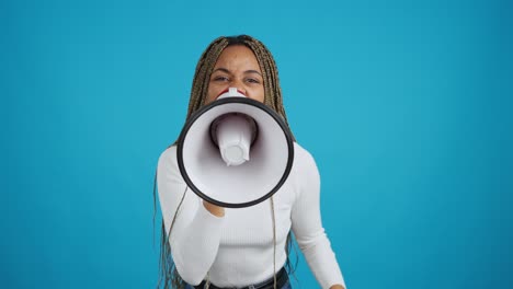 young black woman shouting into megaphone against blue background