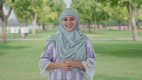 happy muslim woman talking to the camera in park