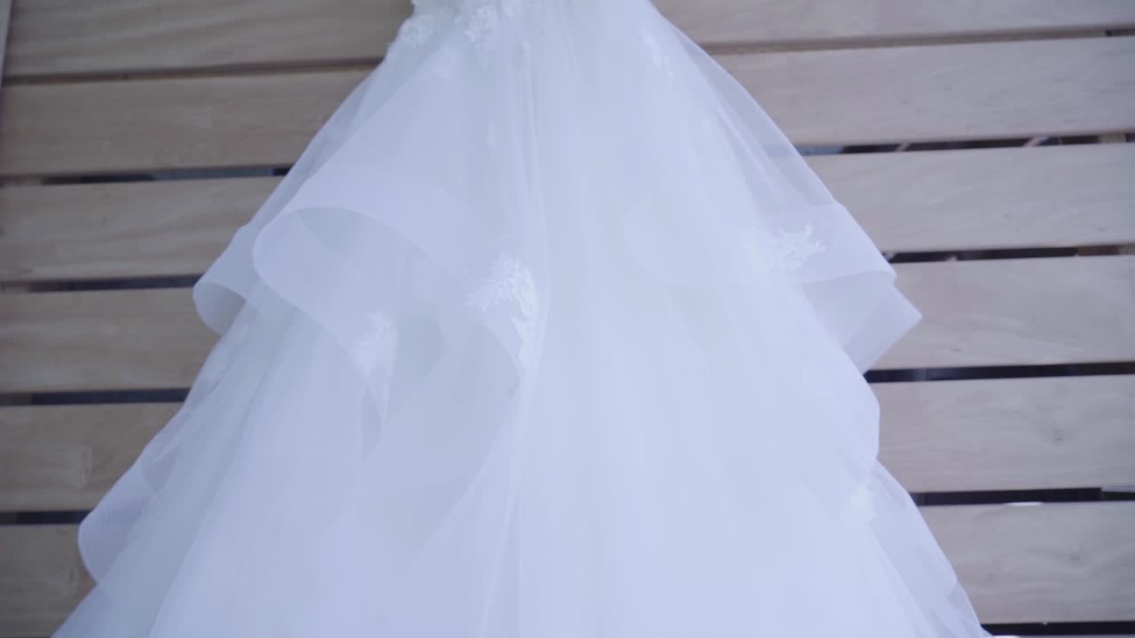 hermoso vestido de novia blanco colgando de un gancho