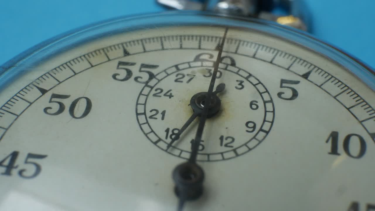 reloj de parada metálico analógico sobre fondo azul