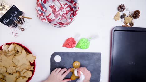 Decoración-De-Galletas-De-Jengibre-Con-Bolsas-De-Cobertura-Que-Contienen-Glaseado-De-Color-Blanco,-Rojo-Y-Verde