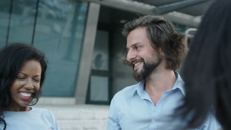 portrait of three business people shaking hands and talking at the street