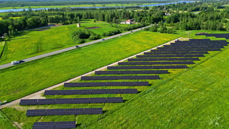 aerial drone fly above solar panels, rural countryside green area, road traffic