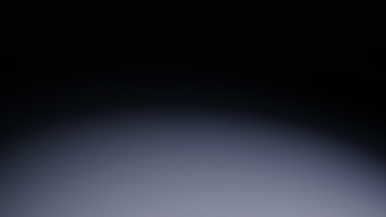 Slow-motion wide shot of white die falling in middle of screen and bouncing