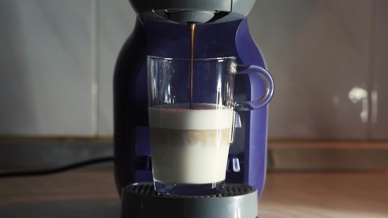 Making capuccino on a coffe mashine. Shot in real time and slow motion. Set on a kitchen counter with studio lighting.