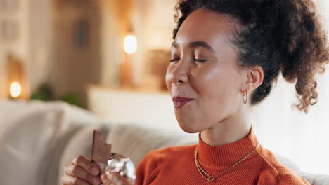 mujer disfrutando de una barra de chocolate en casa