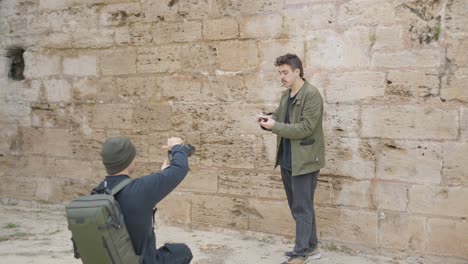 photographer taking photos of a person near a stone wall