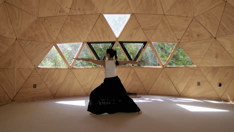 joven practicando posturas de yoga calmantes en un estudio tranquilo y geométrico, con un ambiente al aire libre pacífico, la postura de saludo al sol centrada