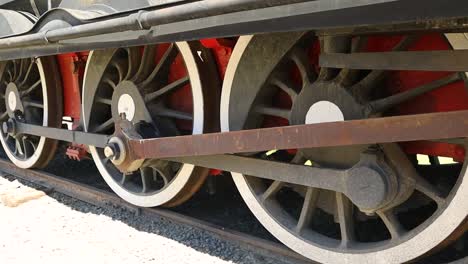 Old-Steam-Locomotive-Wheels-on-Railroad-Track,-Pan-Shot