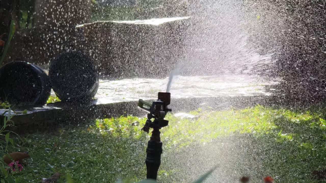 정원 스프링클러가 잔디에 물을 주고 있다