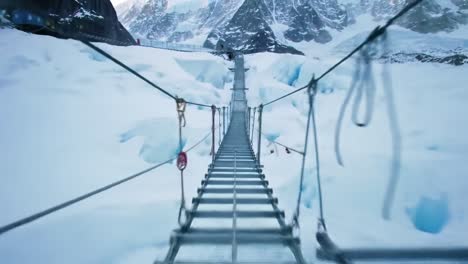 a breathtaking view of a suspended bridge that crosses a glacier, showcasing the icy terrain and towering mountains nearby. adventure seekers navigate this exciting pathway high above the snow.