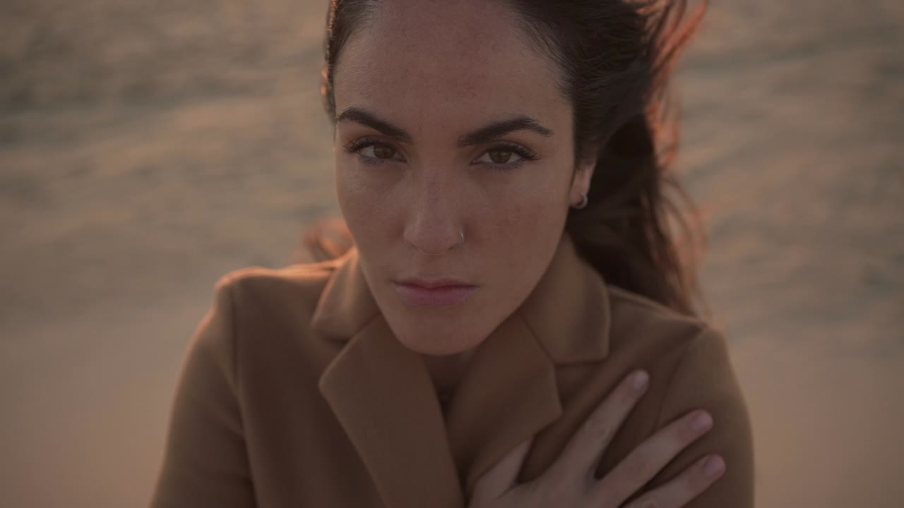 mujer tierna en la orilla del mar en un día ventoso