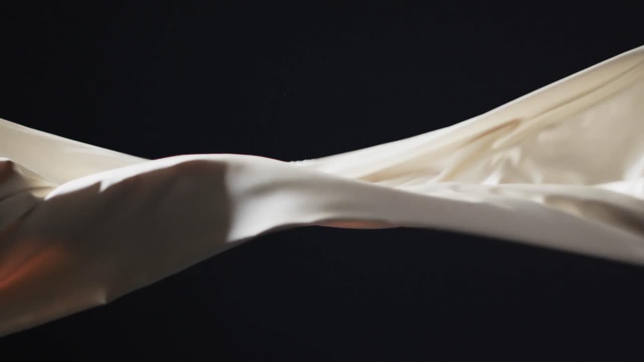 검은색 배경 위에 복사 공간과 함께  ⁇ 색 천을 불어 넣는 애니메이션