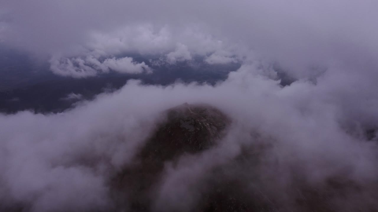 Drone flying over the mountains and through the clouds