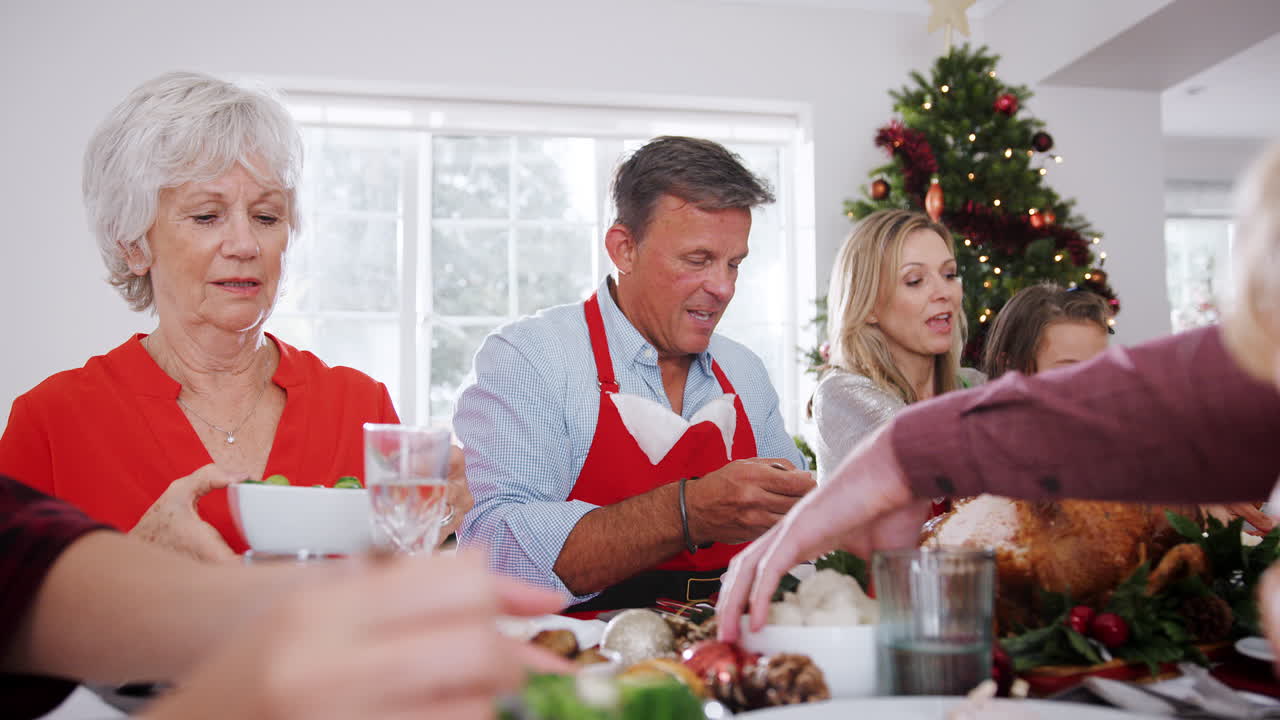 familia de varias generaciones sentada en la mesa disfrutando de la comida de navidad en casa juntos