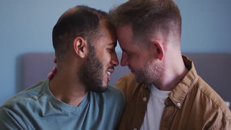 pareja de hombres homosexuales multiétnicos abrazándose y sonriendo