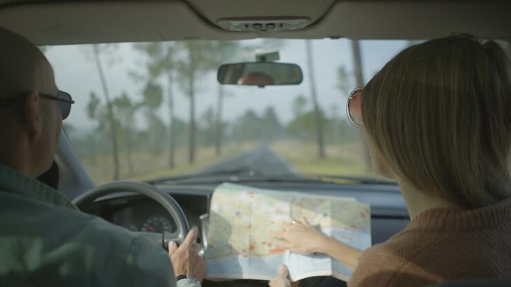Coppia in auto che discute il percorso sulla mappa.