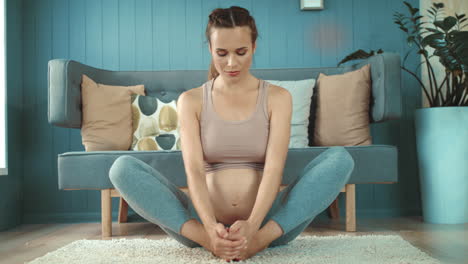 closeup smiling pregnant woman practicing prenatal yoga at home.