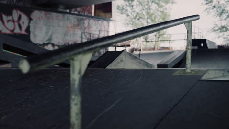 Skateboarding-rail-at-skatepark-with-graffiti-wall.-Urban-training-place