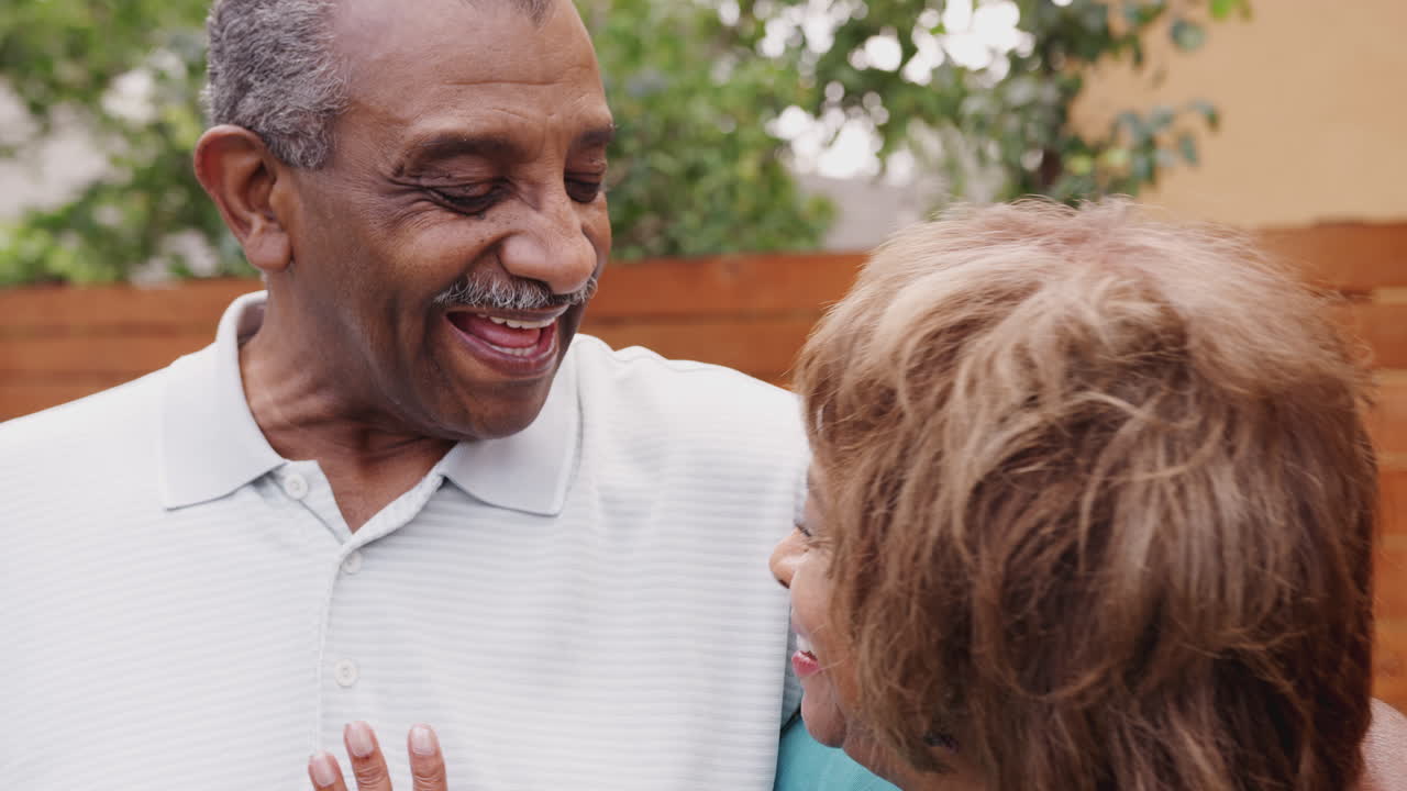 Happy senior black husband and wife embracing outdoors, close up