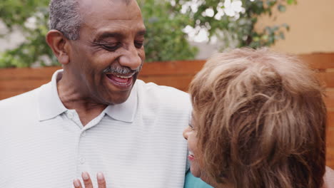 happy senior black husband and wife embracing outdoors, close up