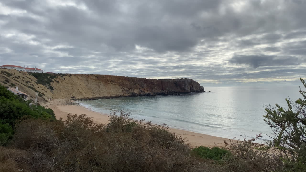 Surfers wait for waves under soft twilight light at Mareta Beach, Sagres, where peace meets energy