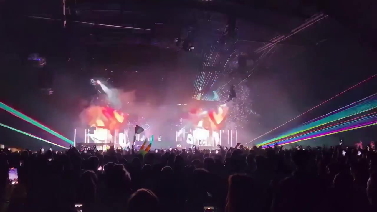 Folla energica si gode un vivace spettacolo di luci laser a un concerto di musica al chiuso