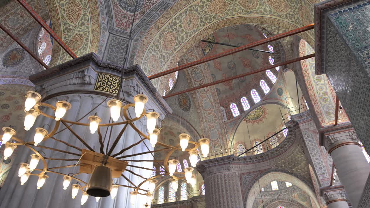 A slow pan left reveals the massive "elephant foot" columns and grand arches of the Blue Mosque in Istanbul, Turkey. A stunning look at Ottoman architectural mastery and scale