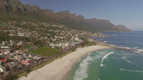 an aerial view shows waves cresting on the shore of camps bay in cape town south africa