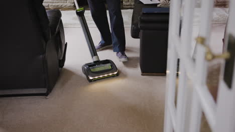 elderly man vacuuming the living room