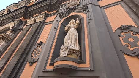 statue on ornate wall with graffiti