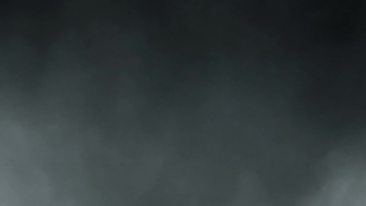 Thick Gray Smoke or Fog Swirling Against a Dark Background
