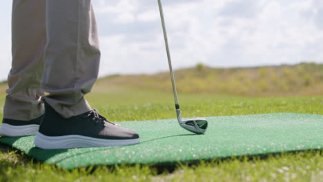 um homem afro-americano a bater uma bola de golfe no campo de golfe.