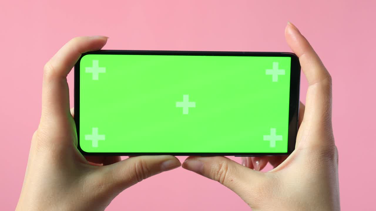 은 녹색 화면으로 스마트폰을 들고 있는 여성 손의 클로즈업으로 앱 또는 웹 사이트 디자인을 위한 복사 공간을 보여줍니다.