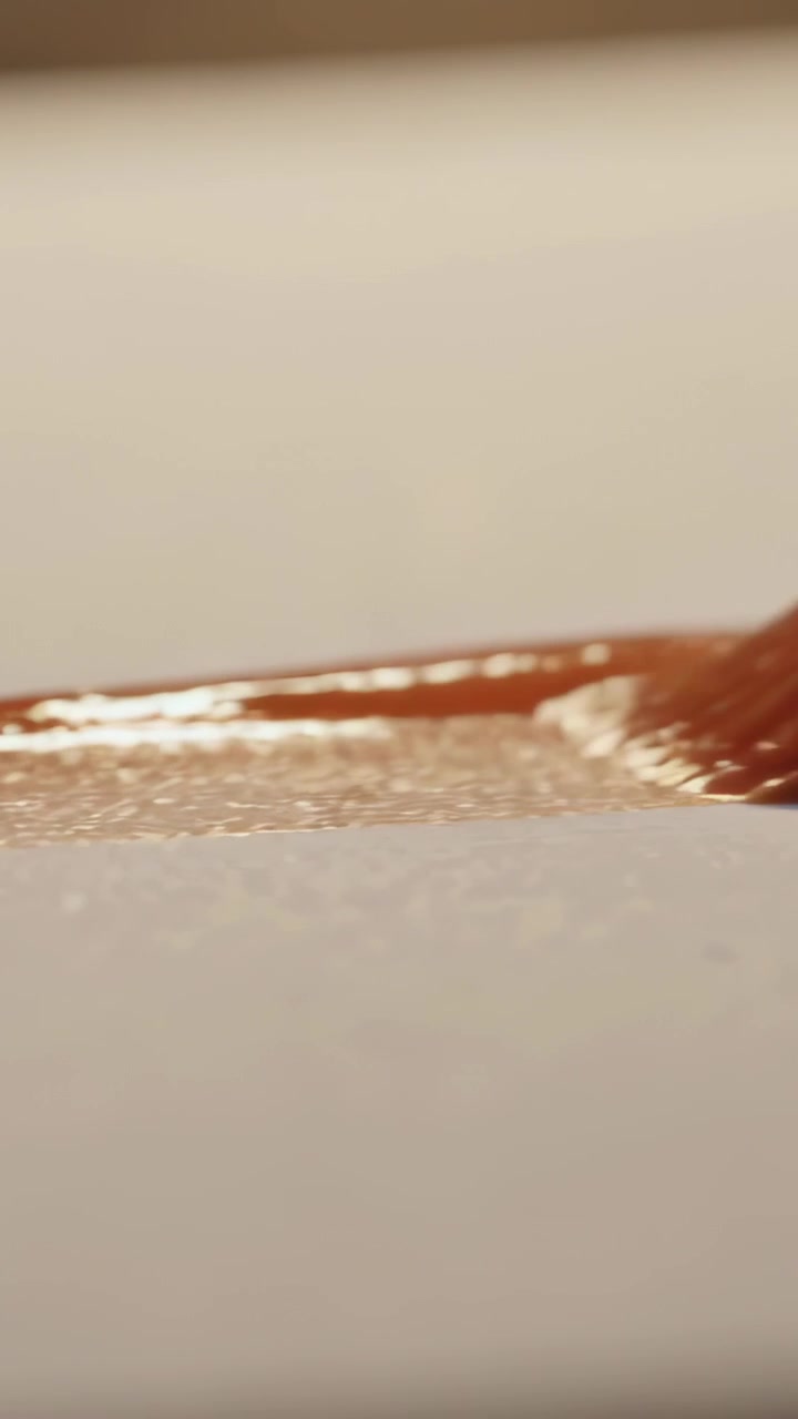 Video verticale: Toccando carta testurizzata sulla scrivania, pennello rotondo che dipinge una pennellata arancione con ghiera.
