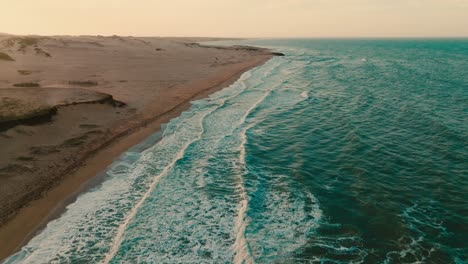 Aerial-level-shot-of-the-desert-beach-and-the-ocean-in-the-sunset,-Colombia,-La-Guajira