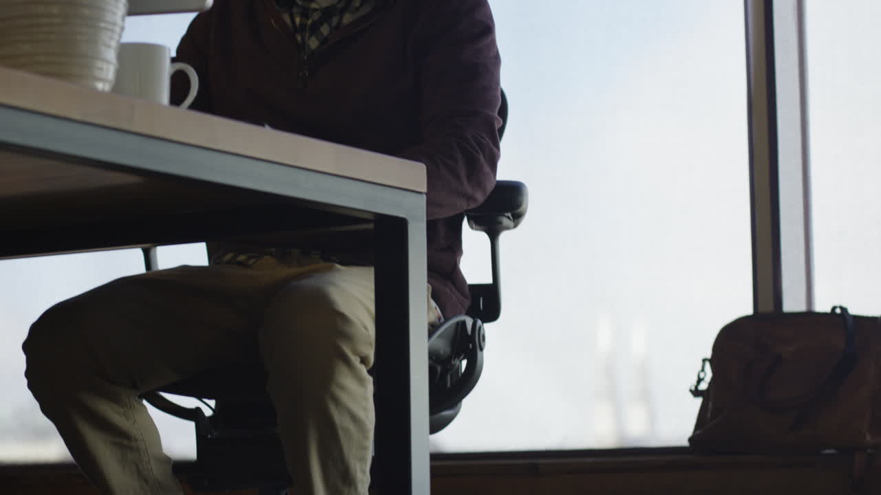 Uomo afroamericano alla sua scrivania con il suo cane in un lavoro ad alta tecnologia