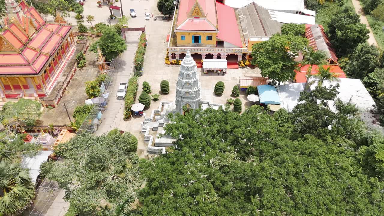 Luftdronebillede af Wat Preah Prom Rath-templet med central stupa, mønstret gård, trimmede haver og omkringliggende bygninger, der viser et roligt religiøst sted i Siem Reap, Cambodja