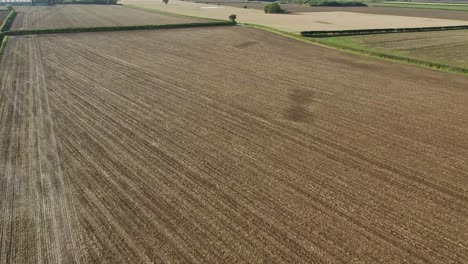 Drohnenaufnahmen,-Die-An-Einem-Schönen,-Klaren-Herbstmorgen-über-Ein-Gepflügtes,-Braunes-Feld-In-Der-Nähe-Von-Hecken-Und-Einem-Feldweg-In-North-Yorkshire,-Großbritannien,-Fliegen